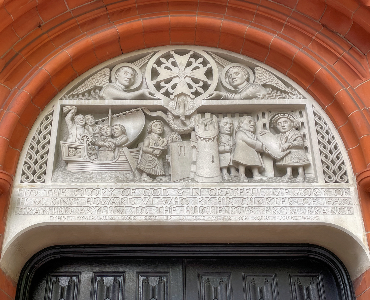 Decorative tympanum at the French Protestant Church, Soho Square, with an inscription reading: To the glory of God & in grateful memory of HM King Edward VI who by his charter of 1550 granted asylum to the Huguenots from France.